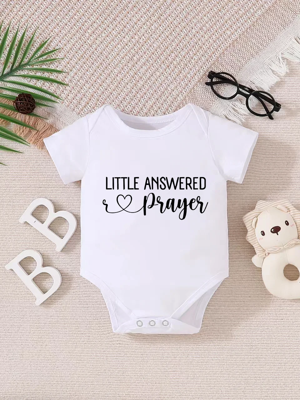 Playful letter-printed baby short-sleeve triangle bodysuit. Button closure for easy dressing