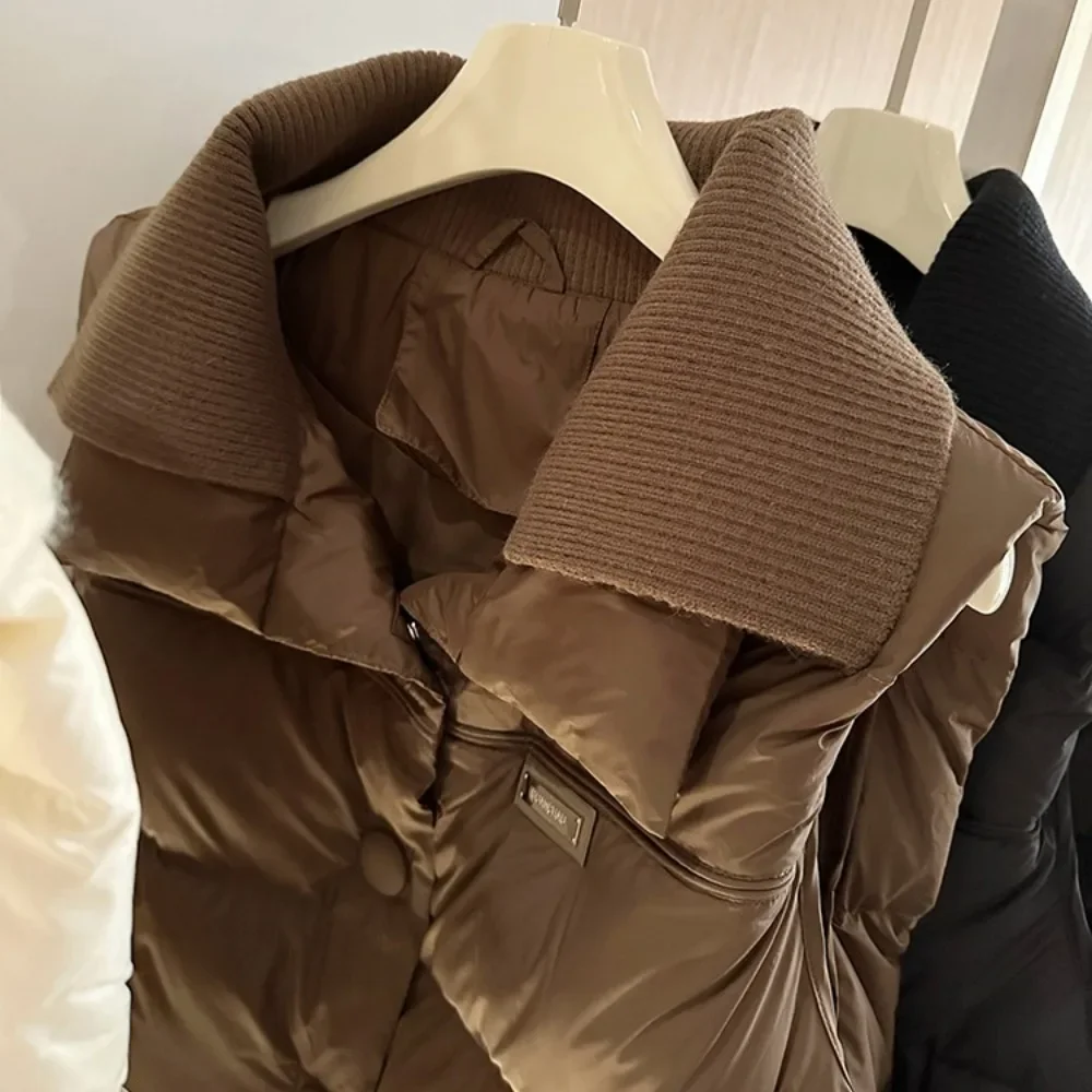 เสื้อกั๊กคอปกสองชั้นเย็บติดกัน รุ่นใหม่ประจำฤดูหนาวปี 2025 เสื้อโค้ทขนเป็ดสีขาวสำหรับผู้หญิง เสื้อกั๊กแฟชั่นแขนกุดแบบสั้น อุ่นสบาย