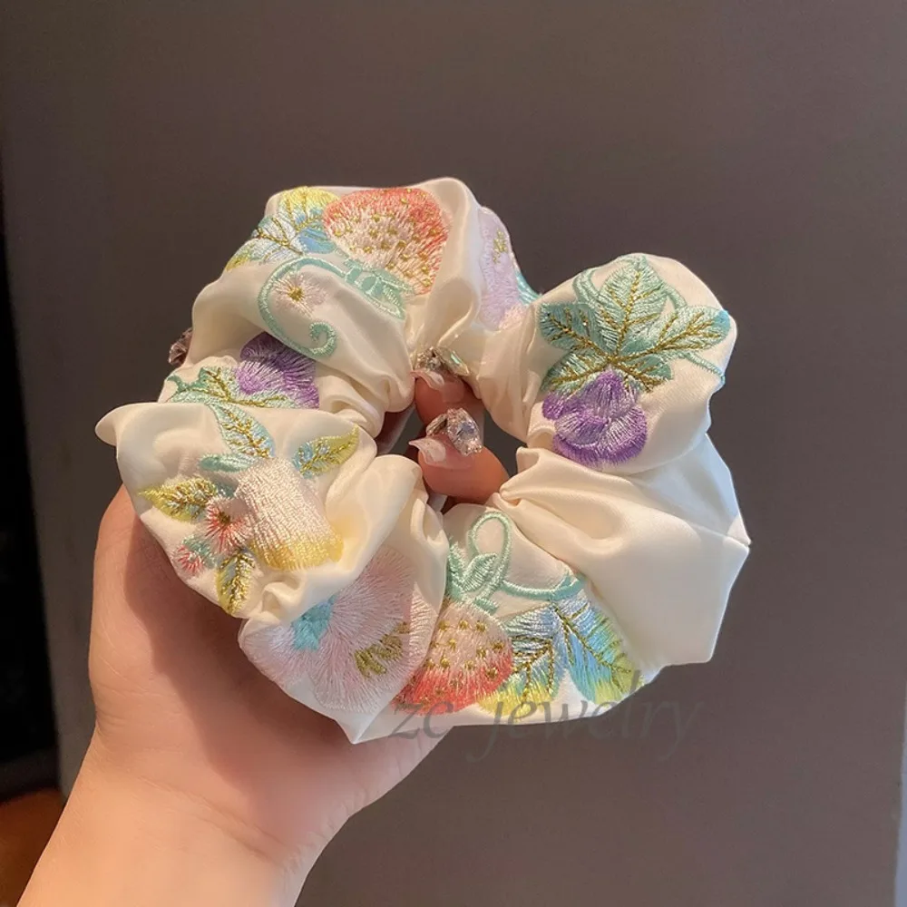 

Элегантная повседневная повязка для волос с вышивкой, большой петлей, круглым элементом и цветочным узором.