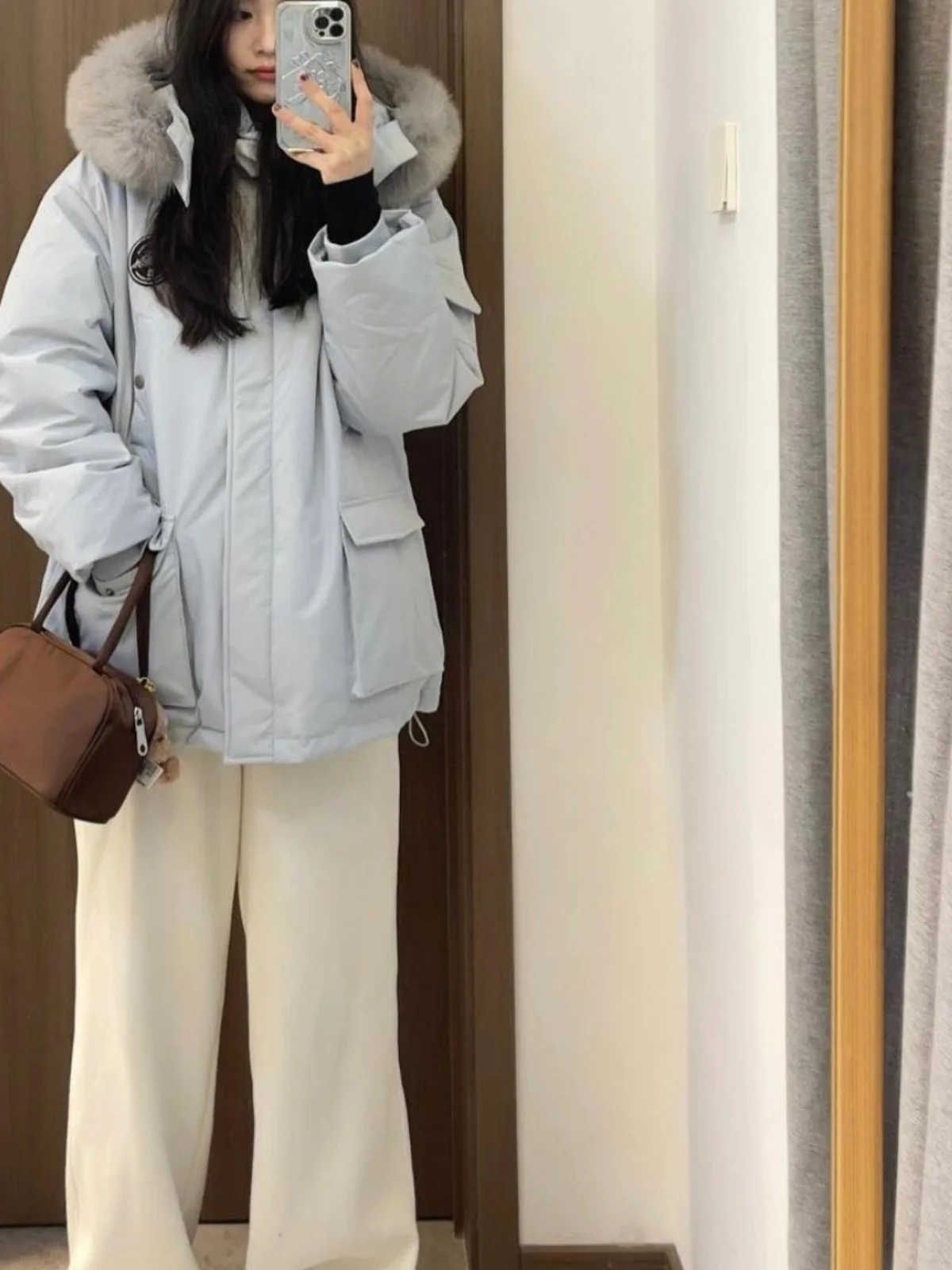 เสื้อโค้ทพาร์กาผู้หญิงสีน้ำเงิน ผ้าฝ้ายผสมขนเป็ด ทรงยาวปานกลาง มีฮู้ด แต่งขนเฟอร์ที่ปกเสื้อ  สำหรับฤดูหนาว เหมาะสำหรับใส่เดินทาง