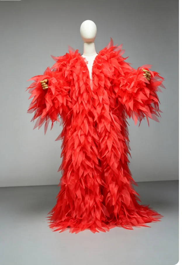Vestido largo de manga larga con flecos de plumas y tela de organza, diseño elegante y con volantes, falda amplia y con capas, ideal para fiestas y eventos de noche, disponible en color personalizado.