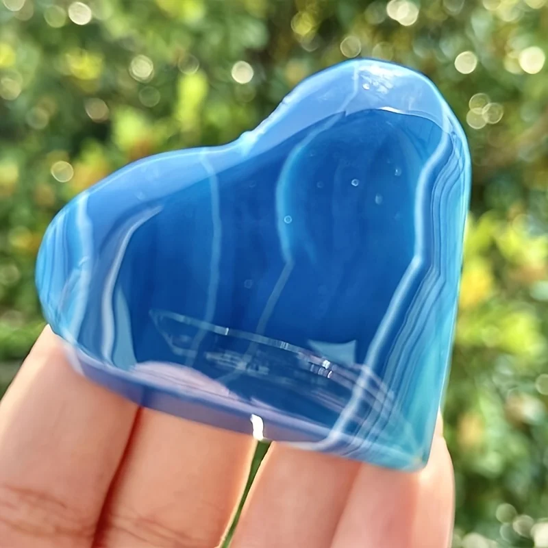 One hand-carved heart-shaped blue agate palm stone crystal. This unique mineral specimen is great for collection and educational