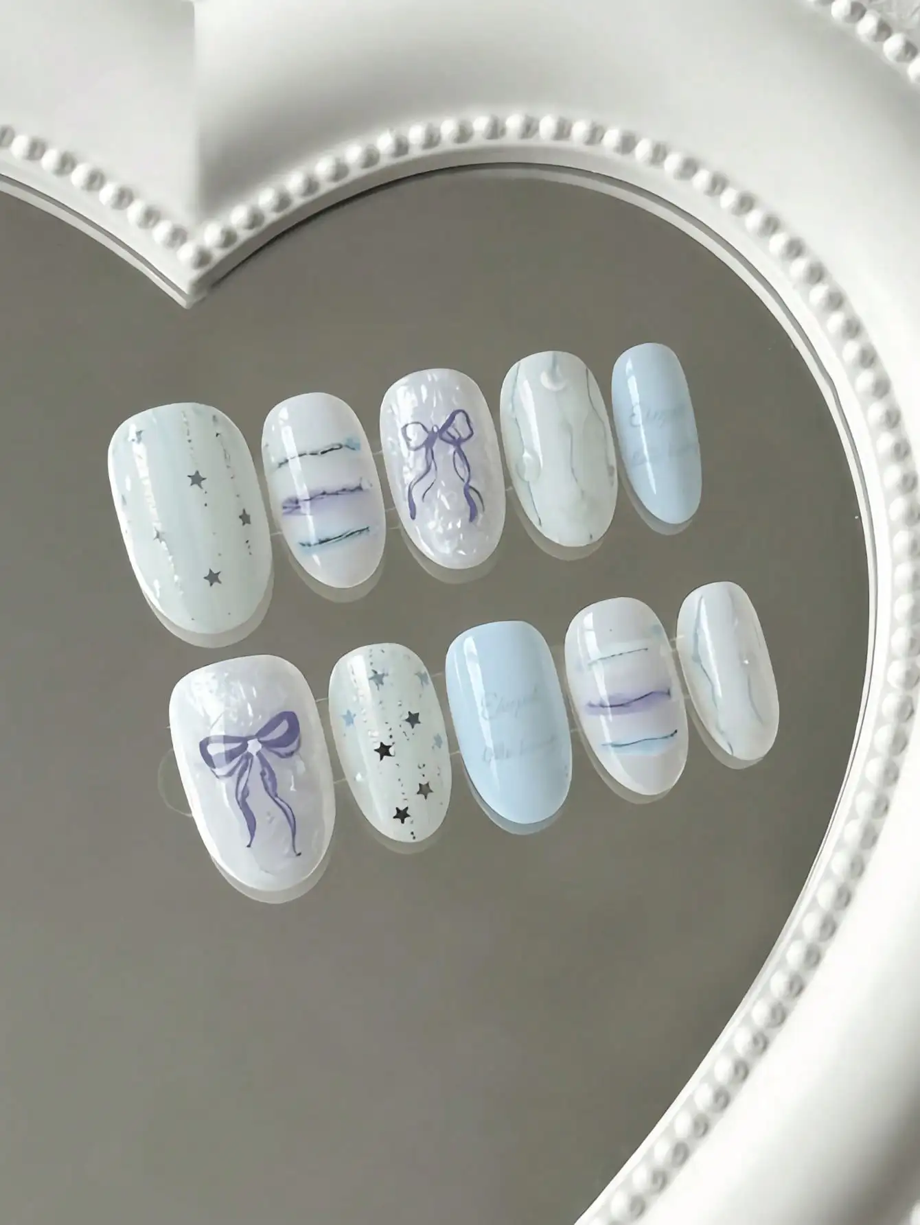 10 Pieces of Oval-Shaped Light Blue-Purple Star-Patterned Press-On Nails, in a Clear and Sweet Girl Style, Featuring Hand-Painted Bows, Stars, and Gradient Stripes, Using Nude-Toned Translucent Colors and Hand-Painted Designs, Suitable for Young Girls and Young Women, Perfect for Daily Commuting, School, and Fresh Date Scenes, Comes with Jelly Glue and Nail File
