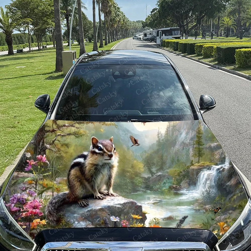 

This car hood features a charming chipmunk in a lush forest scene with vibrant flowers and a serene waterfall backdrop.