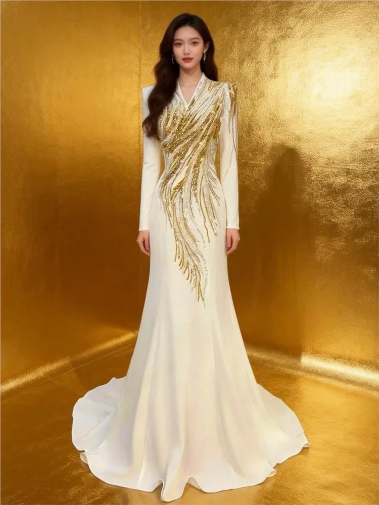 The host wore a long elegant and luxurious dress with light Chinese style featuring white long-sleeved shirt deep collar