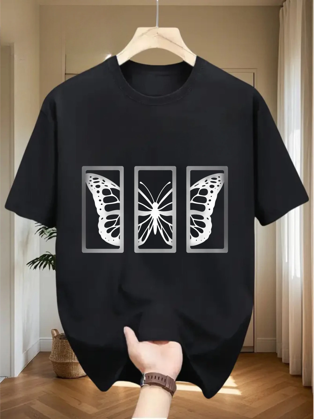 Camiseta negra con cuello redondo y 100% algodón con silueta de mariposa dividida en triple marco rectangular