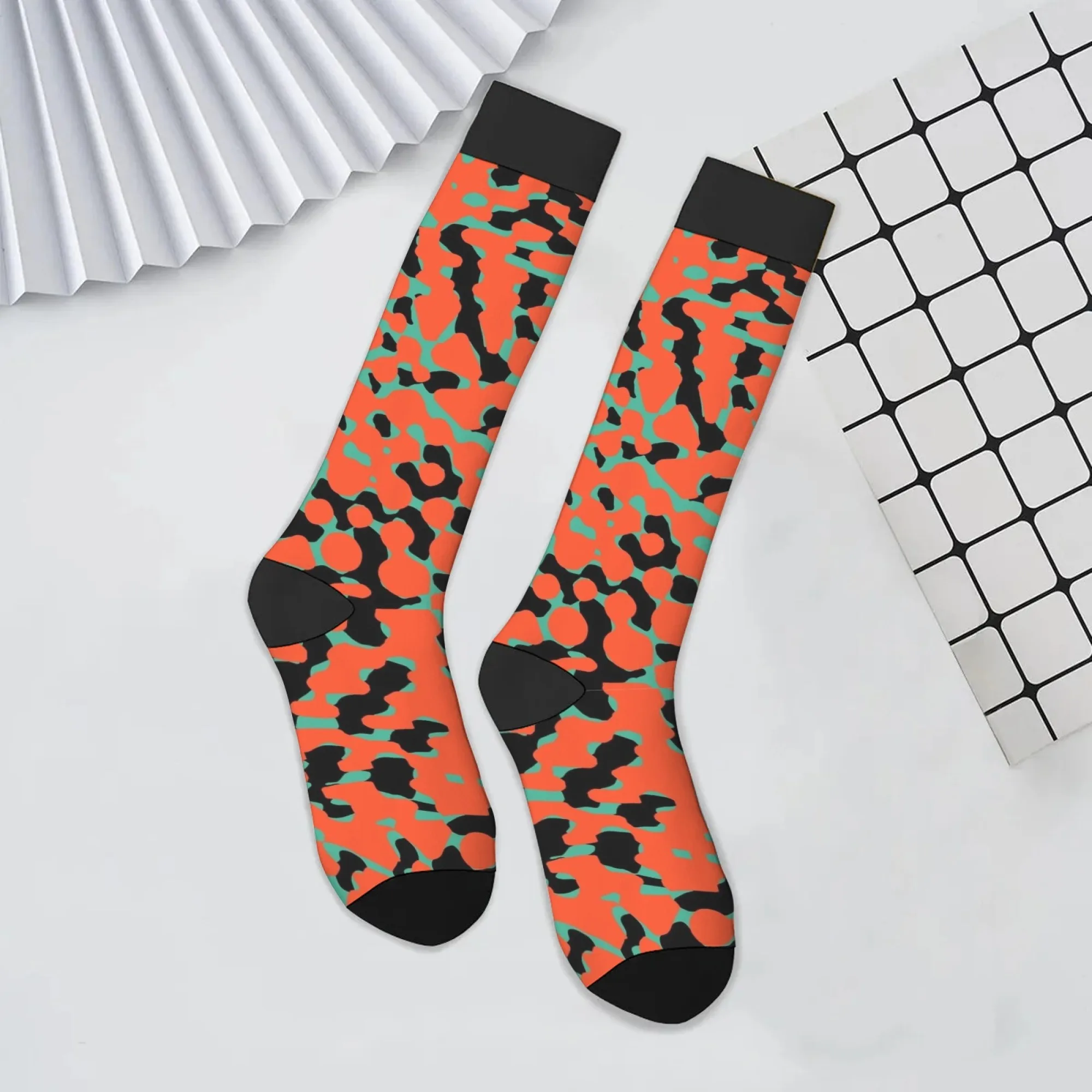Lebendige, farbblockierende Kniestrümpfe mit orangefarbenen Basis, scharfen schwarzen Streifen und blaugrünen geometrischen Formen für den High-Energy-Street-Style