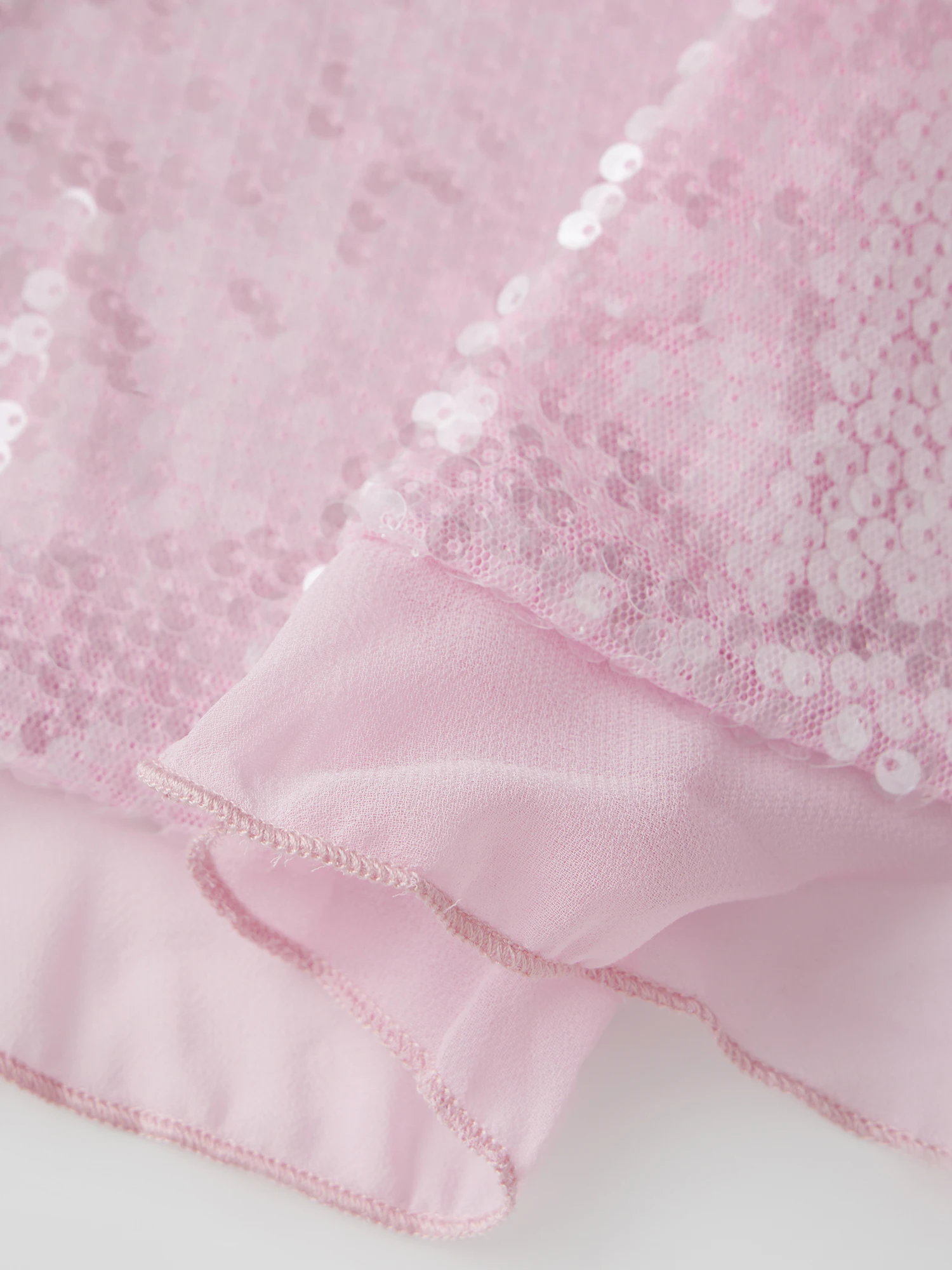 

Элегантная блузка без рукавов, украшенная пайетками, с завязками спереди и нежной отделкой с рюшами — шикарная летняя майка для женщин