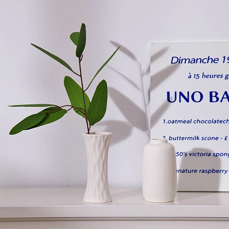 Keramische vazen met groene takken en bladeren