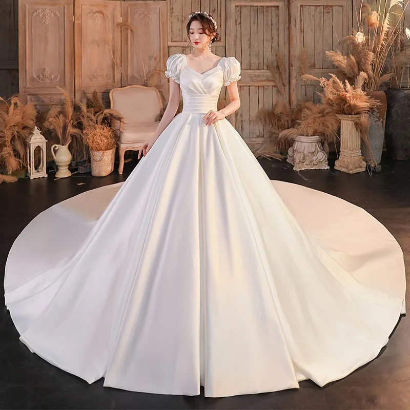 肩が一つになったサテン生地のドレスで、腕を覆う大きなトレーンが付いています。