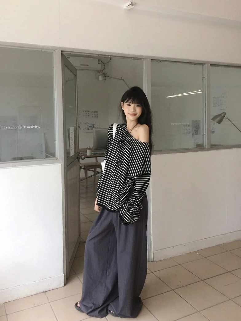 

Непринужденный стиль: женский комплект из двух предметов – полосатая футболка с открытыми плечами и длинными рукавами и свободные повседневные брюки. Модный весенний наряд.