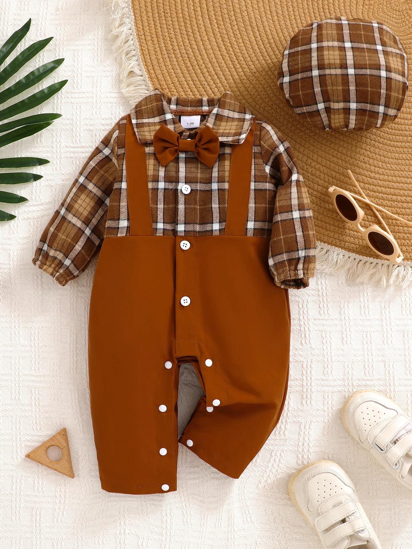 Niedlicher Baby-Jumpsuit mit Karomuster, Fliege und karierter Baskenmütze.