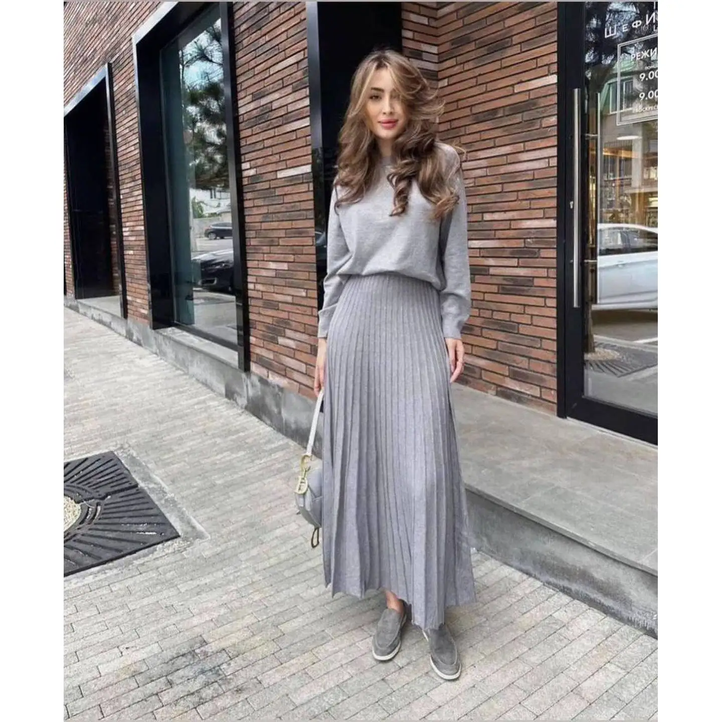 

Комплект: вязаный свитер с круглым вырезом и длинными рукавами, плиссированная юбка с высокой талией. Вязаный облегающий комплект с юбкой. Весна 2026. Женская мода.