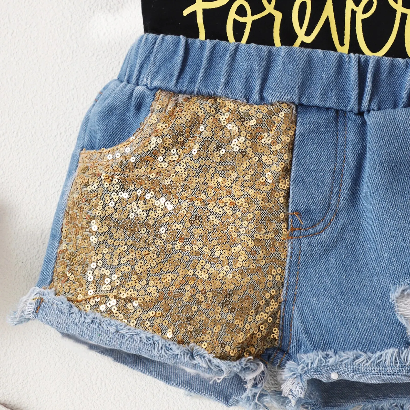 Pantaloncini di jeans traforati con paillettes con bordo dorato e maniche corte stampate con lettera nera da ragazza estiva