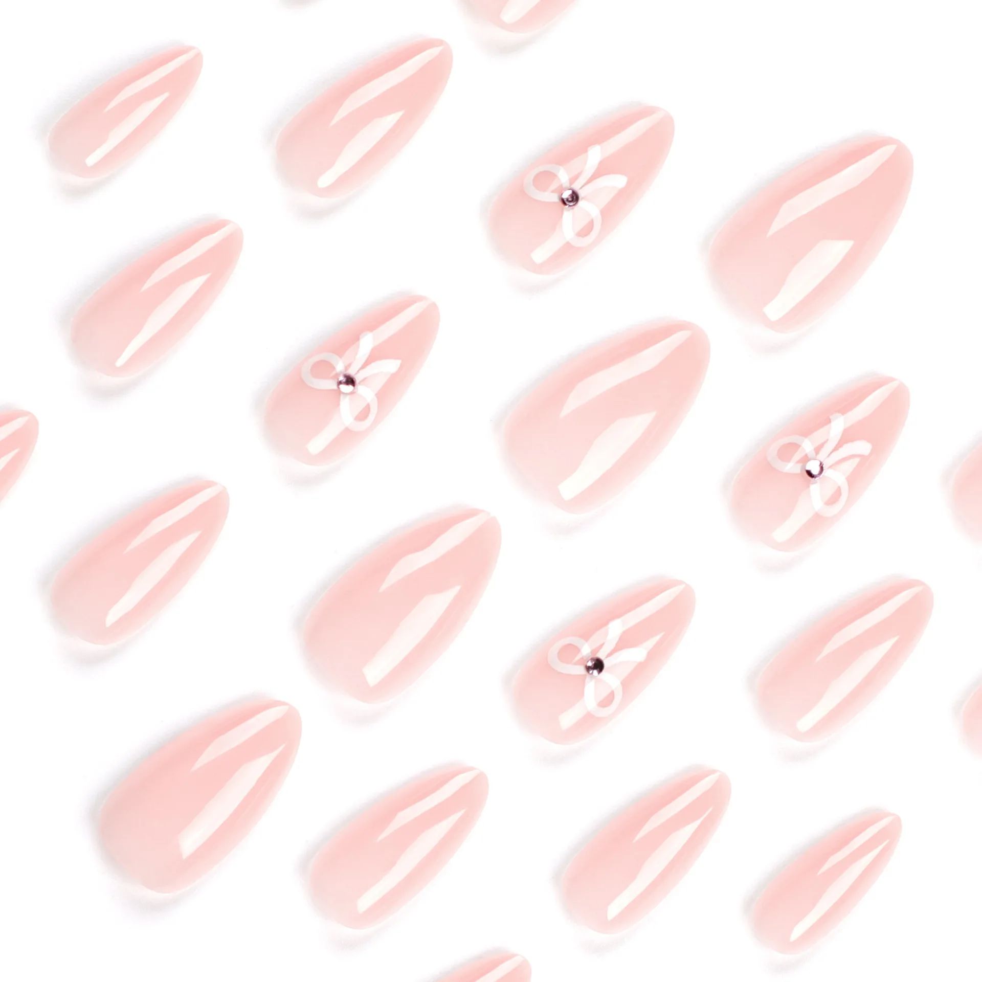 The complete set of 24 long almond shaped pointed nails features a simple white bow and a three-dimensional rhinestone design in