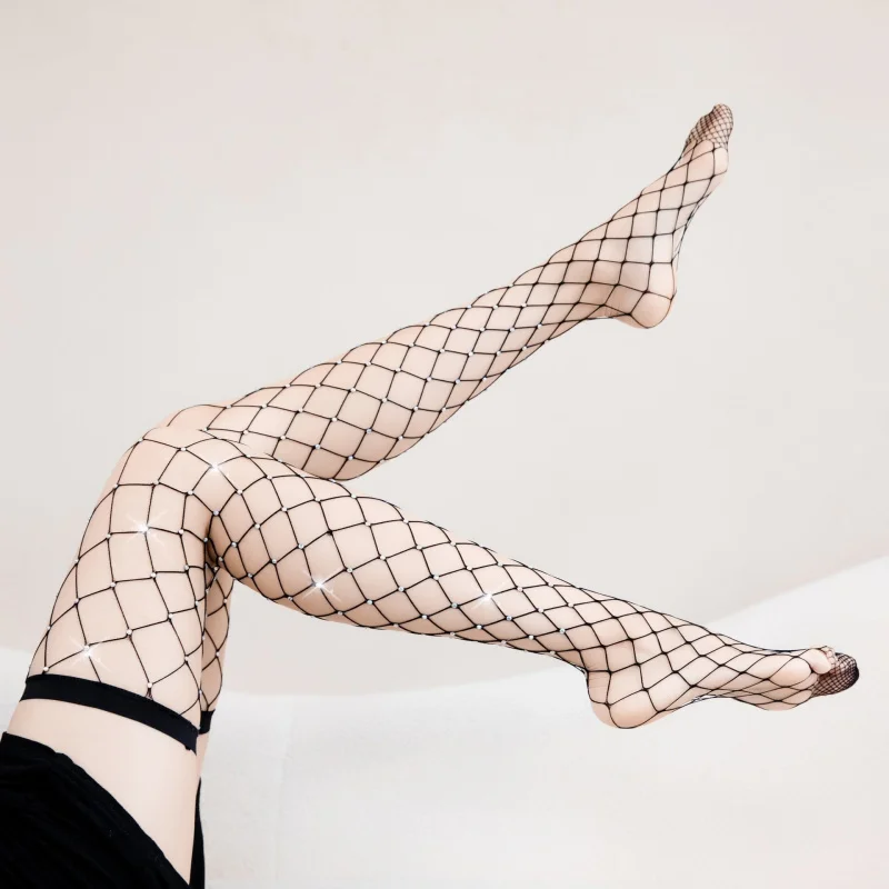 Calze a rete grandi scavate a caldo lucido sopra le calze al ginocchio