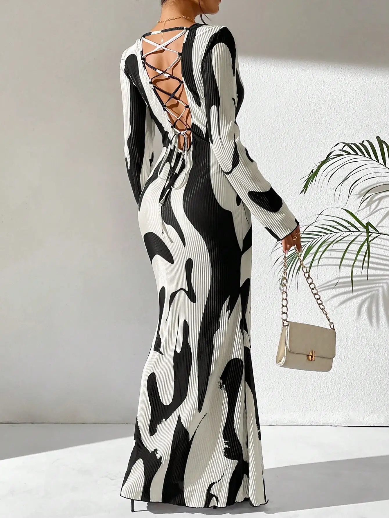 

Красивое женское облегающее платье макси с длинным рукавом и круглым вырезом с открытой спиной и завязками