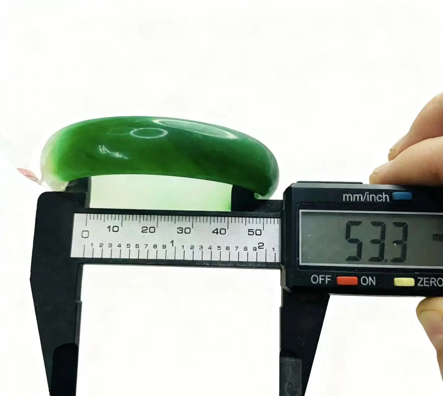 

Один на одной настоящей стрельбе зеленого двухцветного нефритового браслета диаметром 53,3 мм.