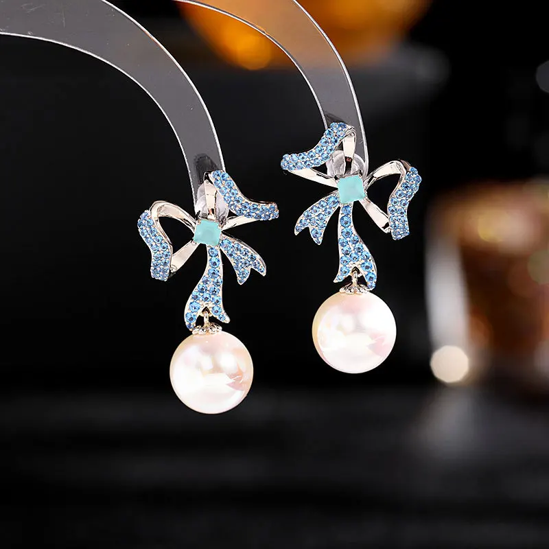 

The new earrings are the versatile and stylish s925 silver needle ribbon bow pearl earrings