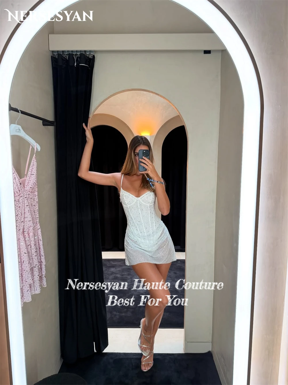 Nersesyan เซ็กซี่ Glitter ค็อกเทลปาร์ตี้ชุดสปาเก็ตตี้สายรัดมินิ Backless V คอแขนกุด Clubbing ชุดที่กําหนดเอง
