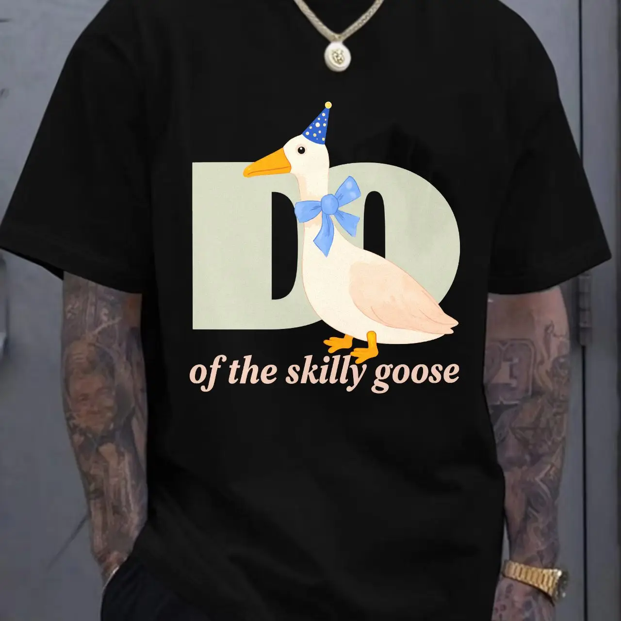 

White T - shirt with Light Green 'D' (Black Hole Design) & Cartoon White Goose (Orange Beak/Feet, Blue Party Hat with White Dots
