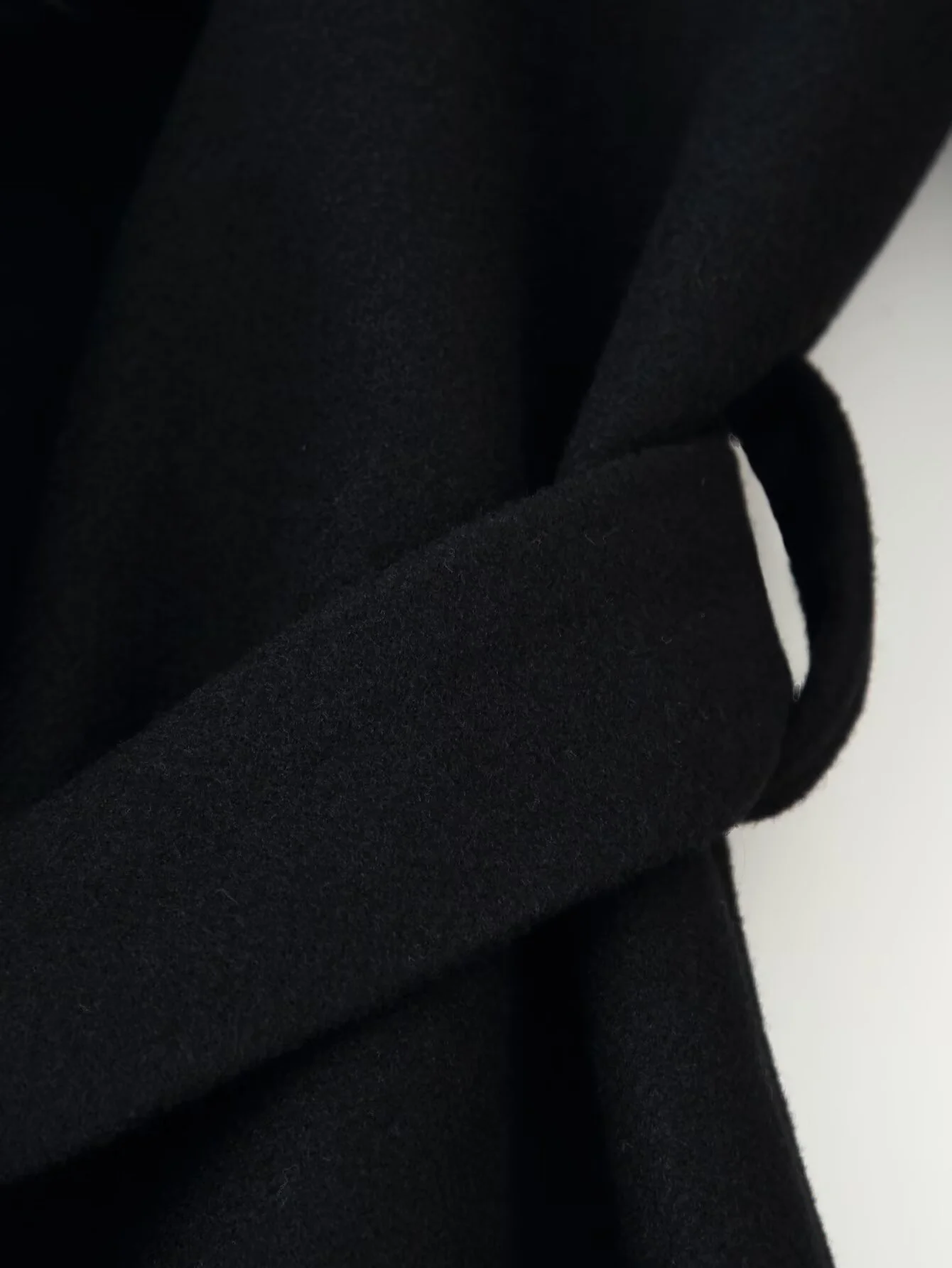 Długi płaszcz damski na zimę 2025, luksusowy, casualowy, z paskiem, kołnierzem z klapami, zapinany na guziki, o luźnym kroju i futrzanym kołnierzem.