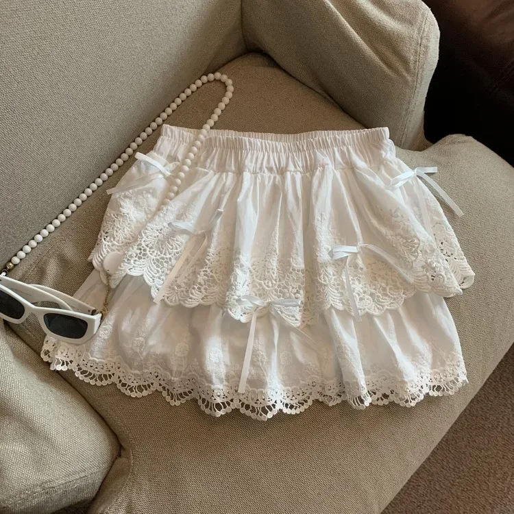 Minifalda blanca con lazo coqueta para mujer, falda acampanada con pantalones cortos, bordado de encaje Kawaii, volantes, capa de retazos, verano 2025