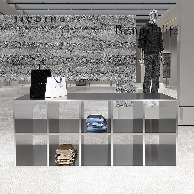 Stainless steel shoes and bags are placed in the middle of the Nakajima table in the clothing store. High and low display stands