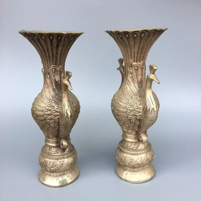 A pair of large white copper and silver plated peacock vases