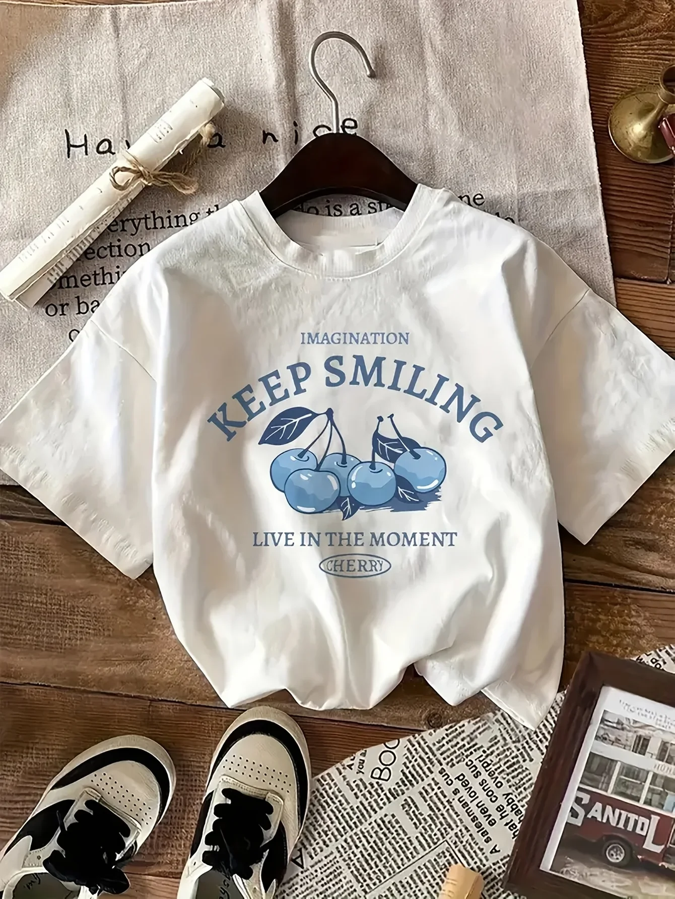 تي شيرت كاجوال بتصميم بسيط مناسب لملابس نسائية صيفية باللون الأزرق الكرز وطباعة حروف ورقبة دائرية وأكمام قصيرة بيضاء