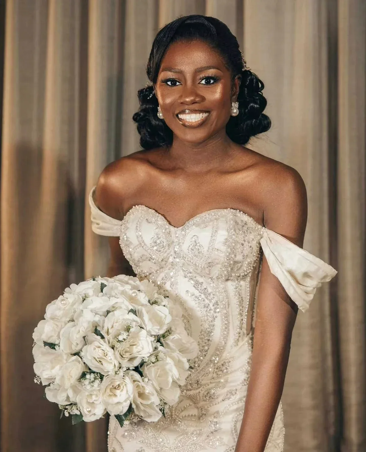 Suknia ślubna syrena z afrykańskimi, błyszczącymi perłami, z odkrytymi ramionami i kaskadowymi falbanami.