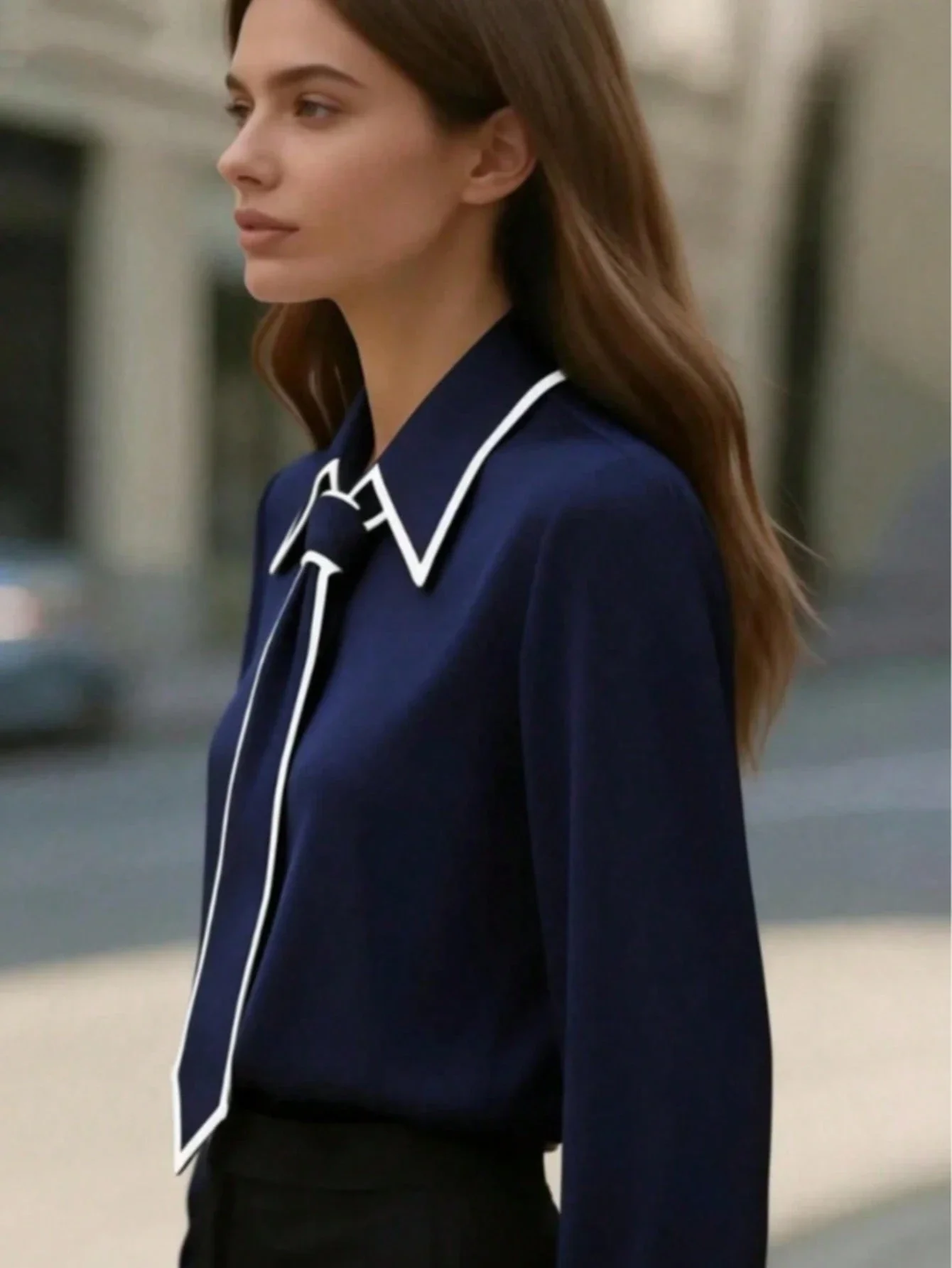 

Женская блузка темно-синего цвета с длинными рукавами, белым контрастным воротником и бантом.