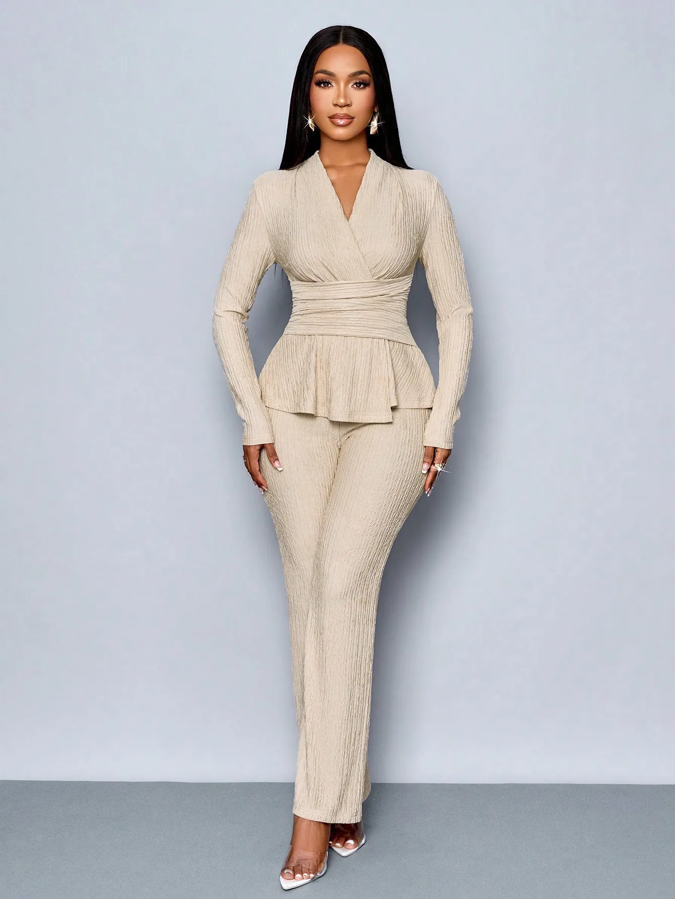 Top a maniche lunghe con scollo a V beige e pantaloni a gamba larga, completo due pezzi da donna, elegante outfit casual.