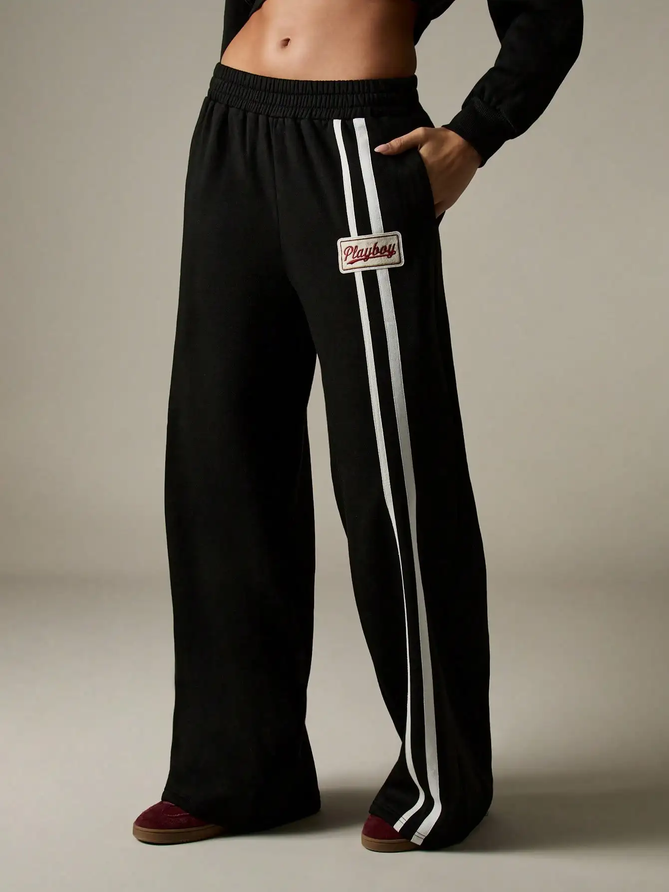 

Черные широкие джоггеры оверсайз с белыми вертикальными полосками и вышитой нашивкой