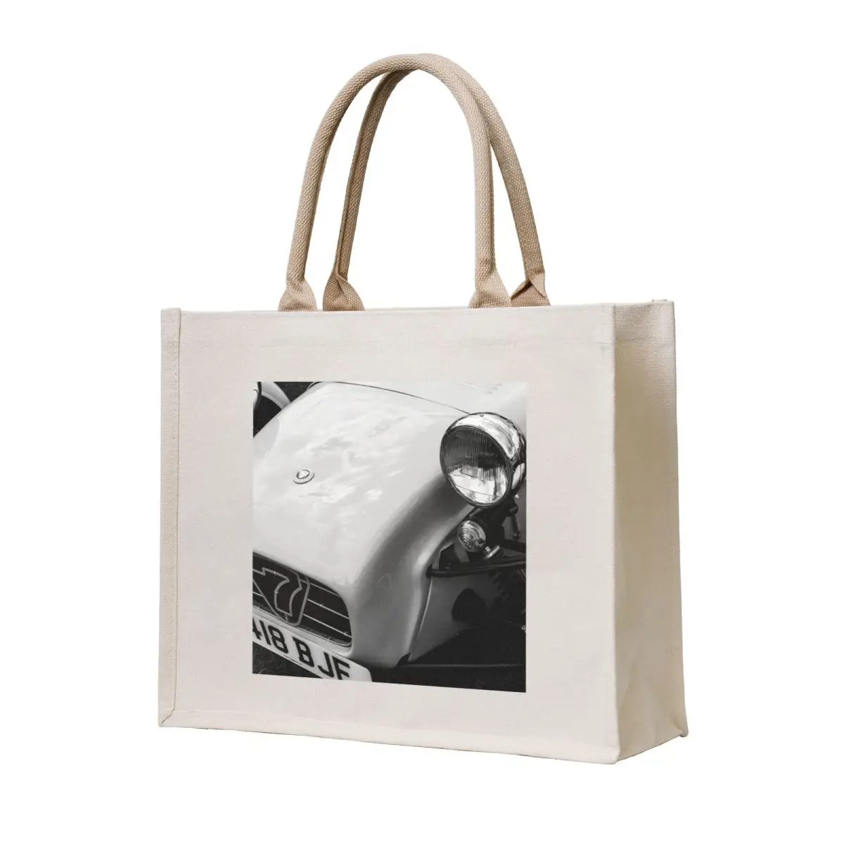 

A black and white image of the front of a 1996 Caterham Super 7 on display at a car show Tote Bag tote bag female bag
