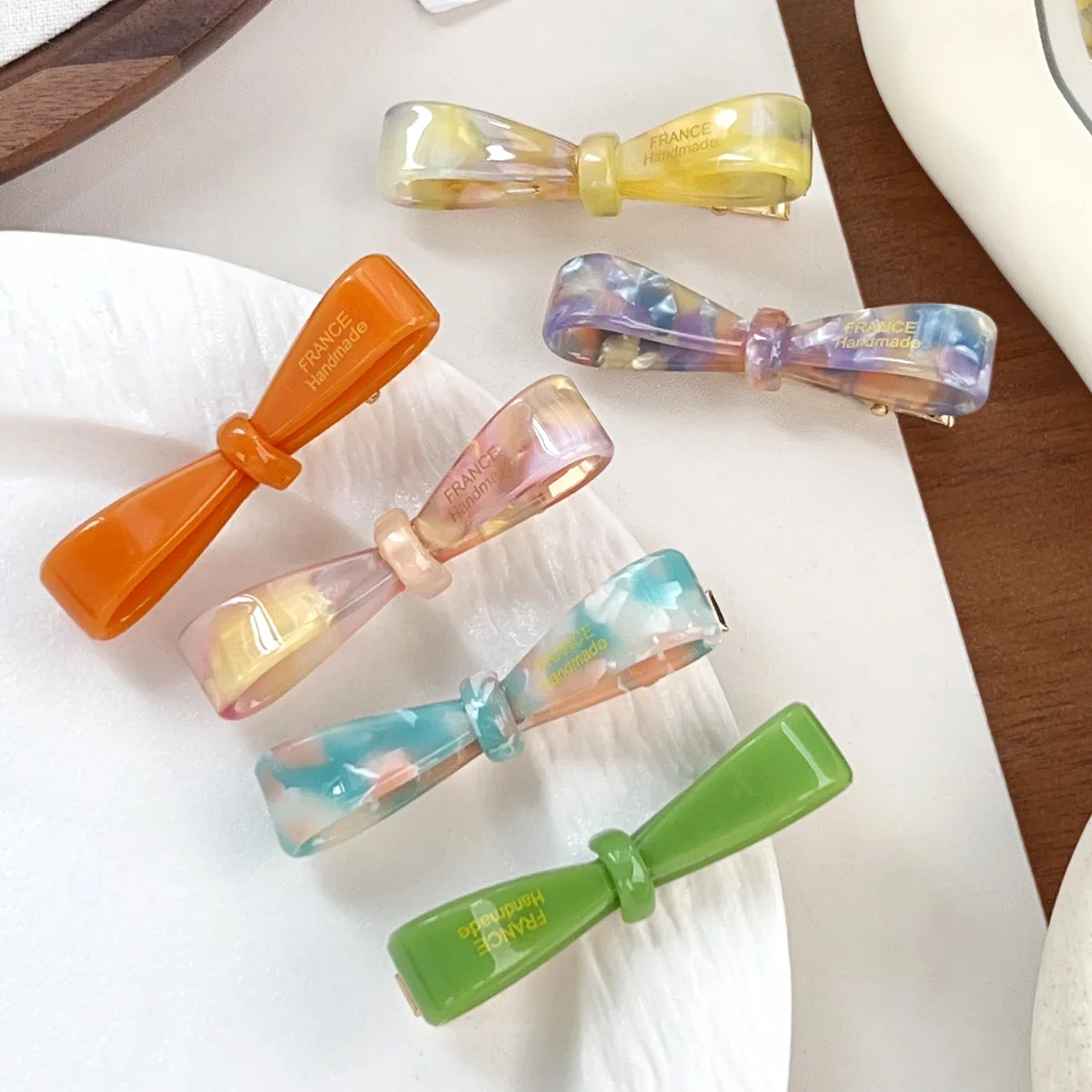 Neue süße und niedliche Haarspange mit Schleife und goldenem Etikett, einzigartige Entenschnabel-Clip aus Acetat, modisches und vielseitiges, sanftes Haar-Accessoire