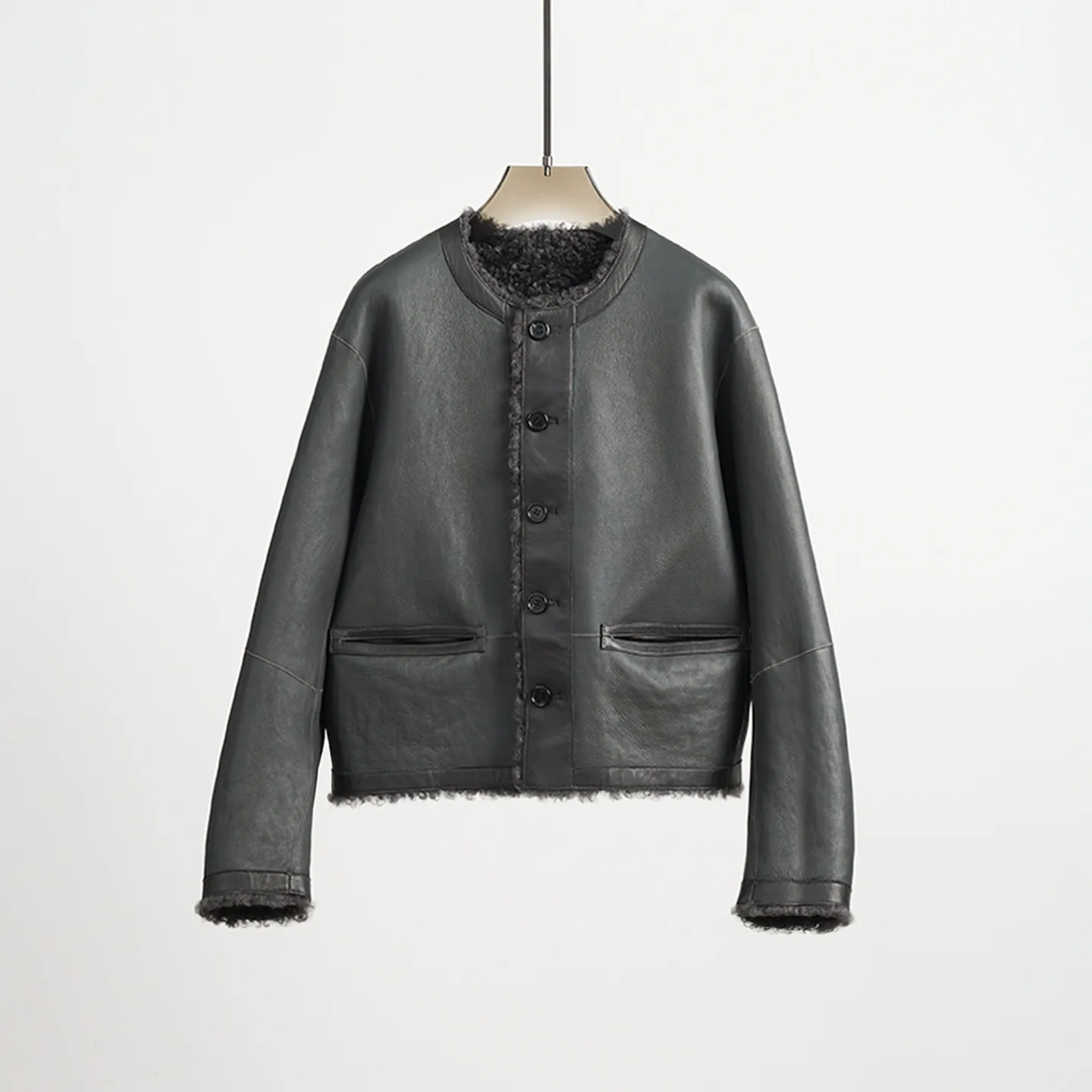 Abrigo de piel reversible recortado y holgado con cuello redondo de punto de lana y piel de oveja de primera calidad ultra minimalista