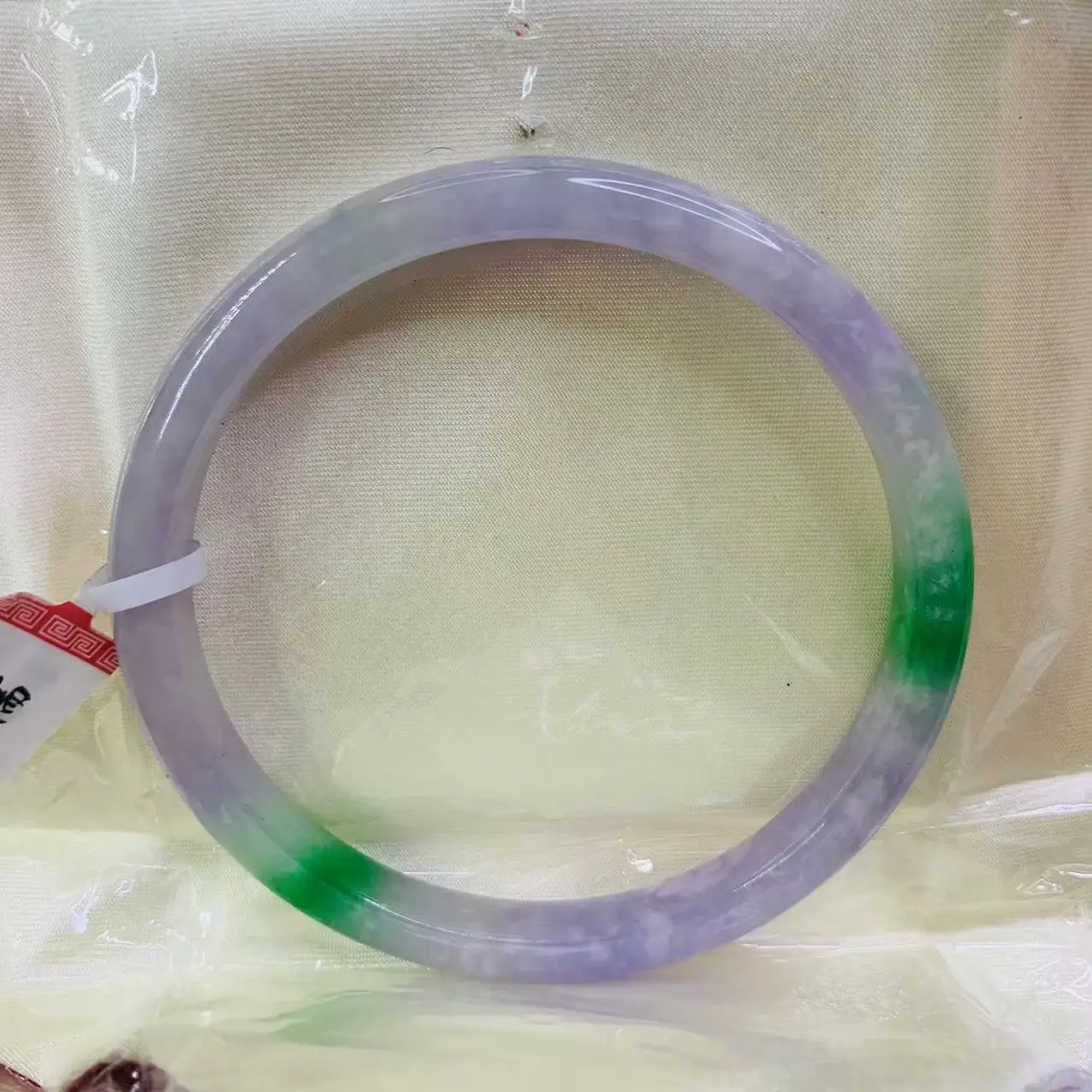 

Natural jadeite bangle photographed with two tone fine strip measuring 62mm