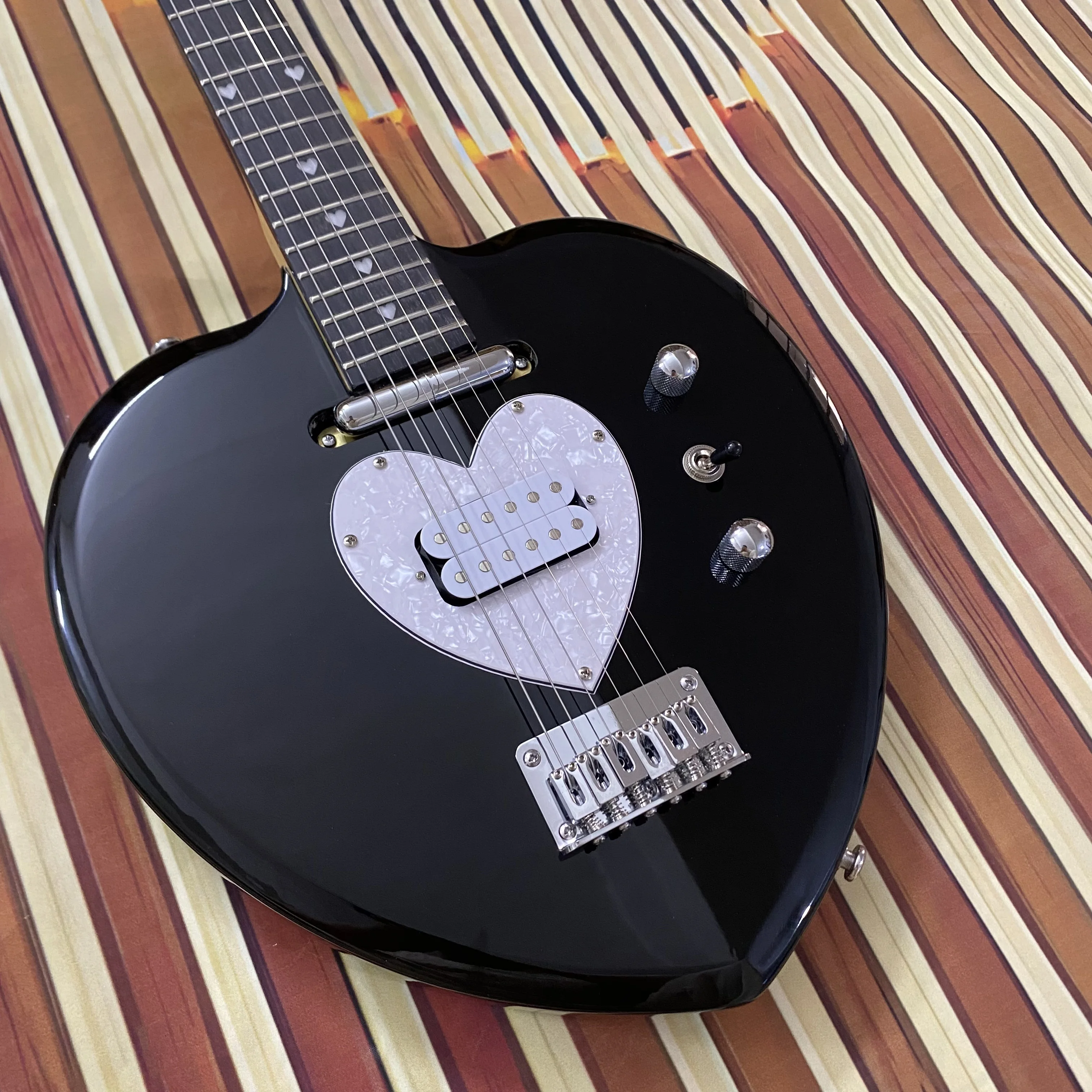 Vicers Guitarra elétrica requintada em forma de coração. Corpo em mogno. Fretboard de jacarandá. Pescoço de bordo. 22 trastes. Ferragens cromadas.