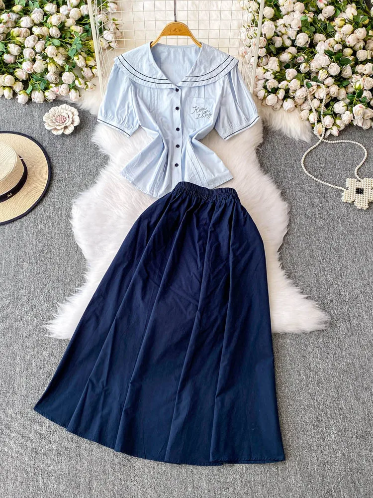 

Сладкая и возрастная рубашка с вышитым темно-синим воротником и рукавами-пузырьками + большая распашная юбка с высокой талией, комплект из двух предметов в студенческом стиле