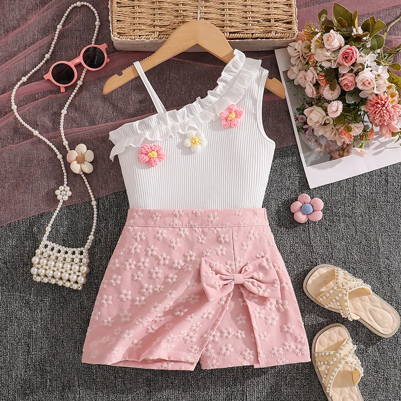 

Комплект из 2 предметов для девочек 4-7 лет: бело-розовый топ с цветочным принтом на одно плечо и юбка-шорты с бантом/однотонный топ в рубчик сзади, повседневный летний детский наряд