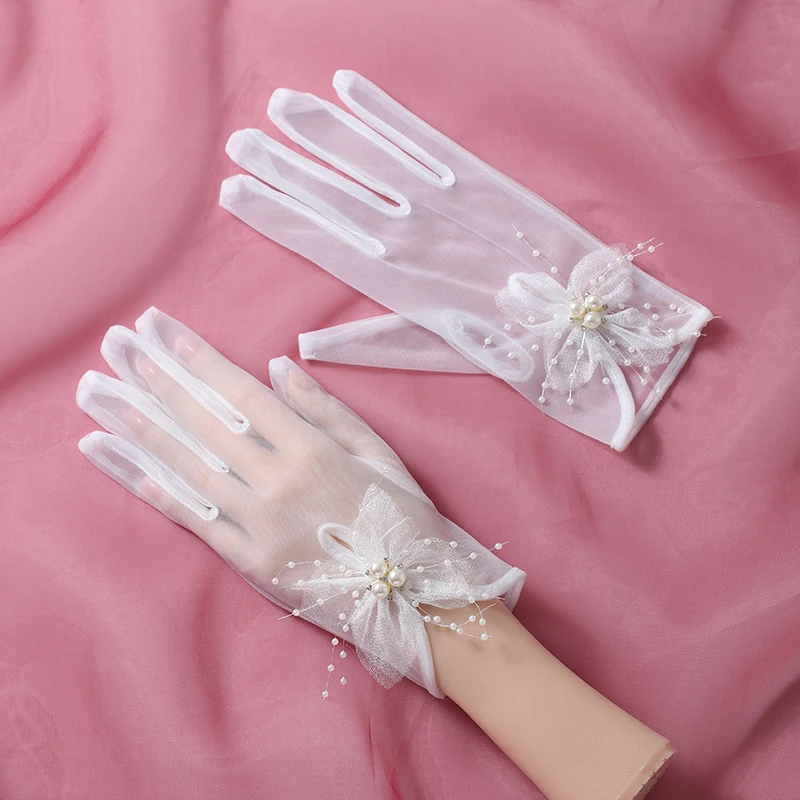 The bride's accessory is a pair of white minimalist flower decorated gloves suitable for women's wedding parties