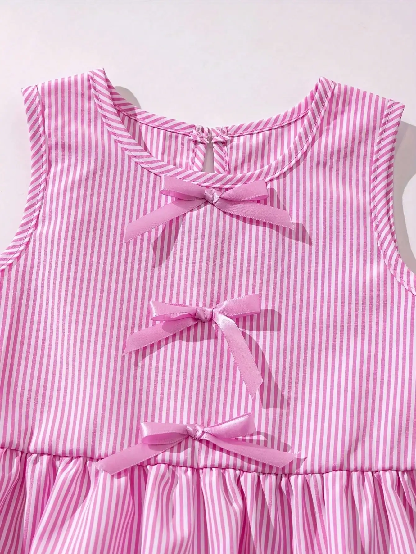 Modisches zweiteiliges Set für Mädchen: rosa-weiß gestreifter Rundhalspullover mit Schnürung, Schleife und Rüschenrand + rosa gestreifte Schmetterlings-Shorts. – Detail 5