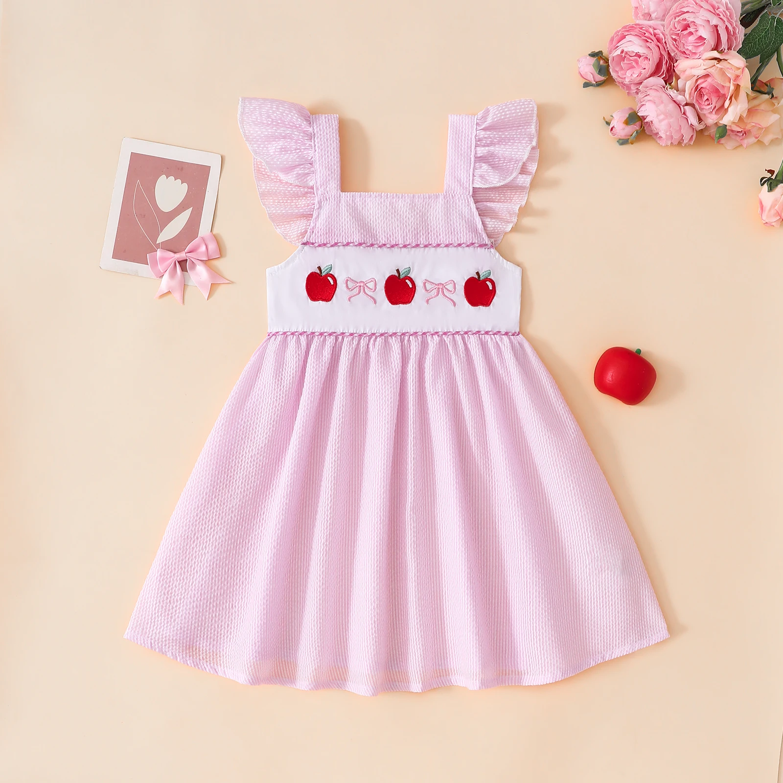 Summer baby girl’s pink apple-print dress with a bow and cap sleeves, sweet and adorable