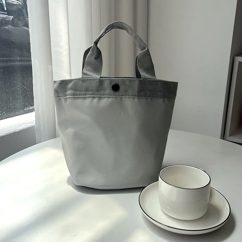 حقيبة غداء أسطوانية كبيرة السعة محمولة باليد مقاومة للماء ومتعددة الاستخدامات للتنقل اليومي بلون بسيط