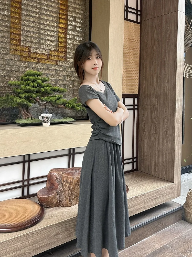 

Комплект из облегающей трикотажной юбки с высокой талией и асимметричной плиссированной футболки — модный летний наряд для женщин