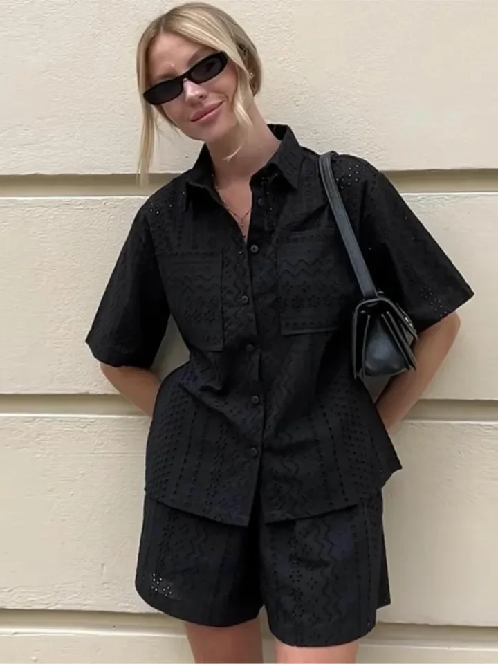 Modny letni komplet dwuczęściowy damski: koronkowa bluzka z krótkim rękawem i ażurowymi detalami oraz krótkie spodenki, damski letni zestaw dwuczęściowy.