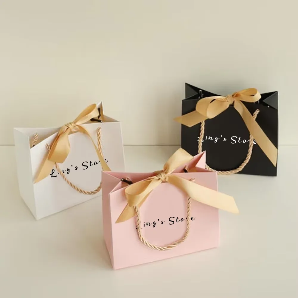 

50/100Pcs 14x6x12cm Jewelry Paper Custom Logo Handle Bag Bowknot Ribbon Fashion Wedding Gift Folder Handbag Cosmetic Packaging