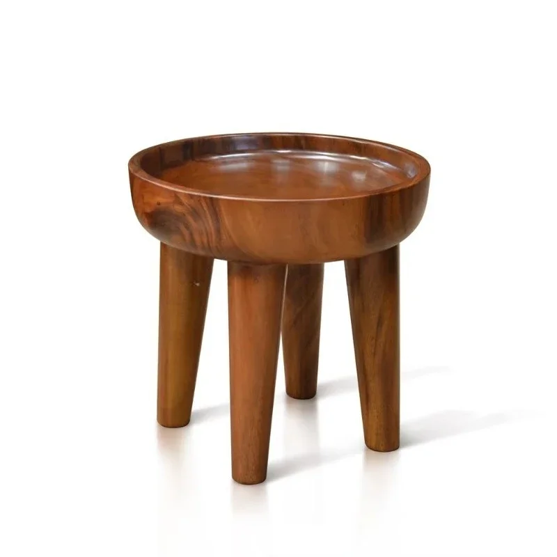 The unique concave of the modern round side table displays items safely handmade from a single piece of wood