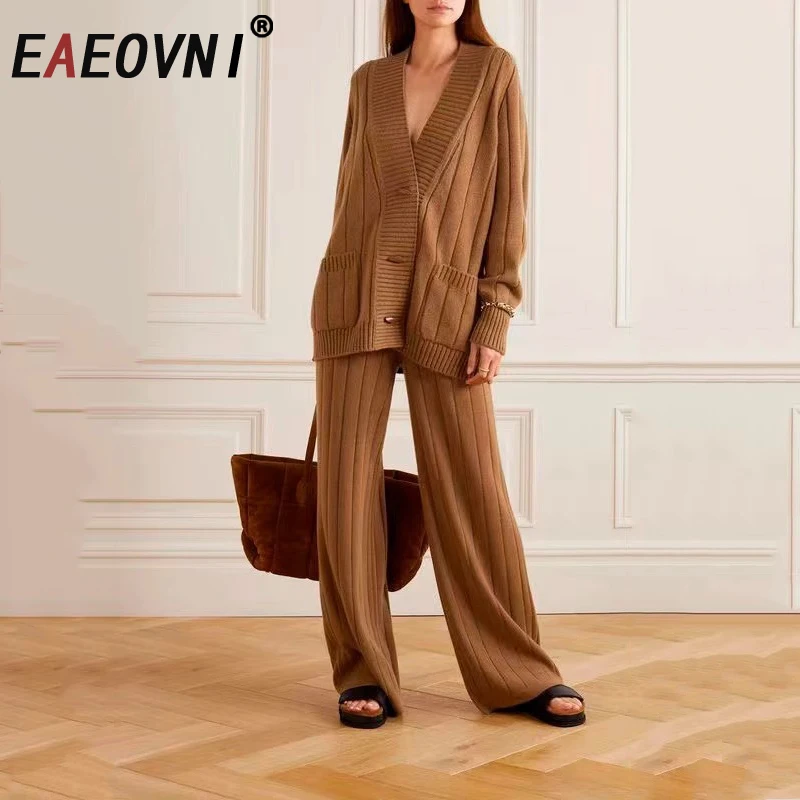 

Комплект из двух предметов EAEOVNI: шерстяной вязаный свитер с V-образным вырезом на пуговицах и брюки с широкими штанинами. Новая коллекция 2026 года.